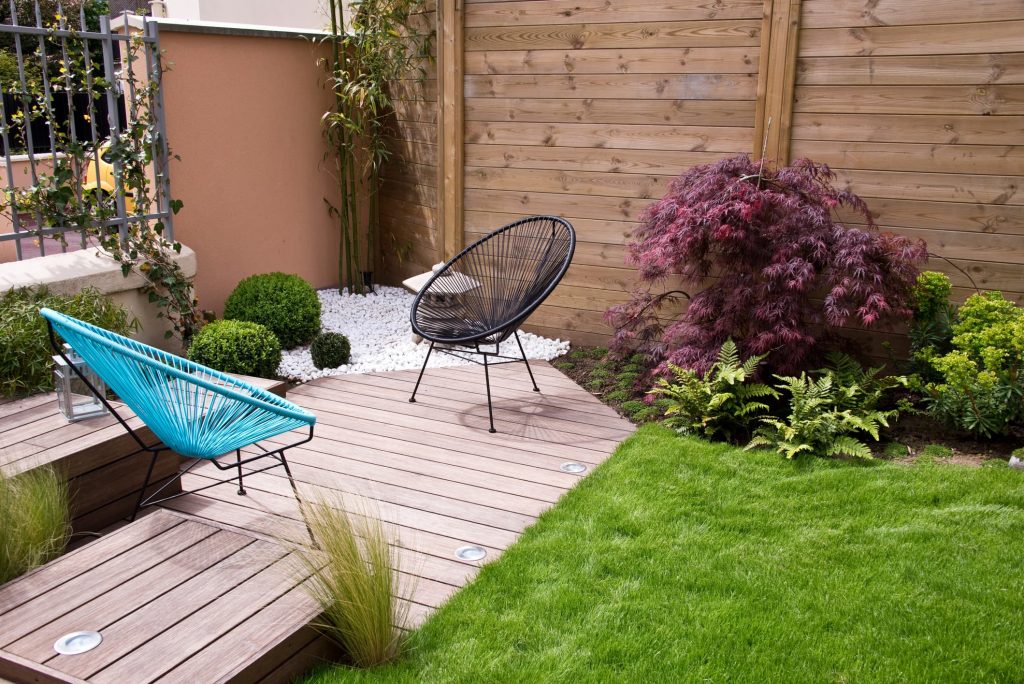 Patio with Acapulco chairs, a Japanese maple and a wood fence, starting photo for Mix&Design expand image