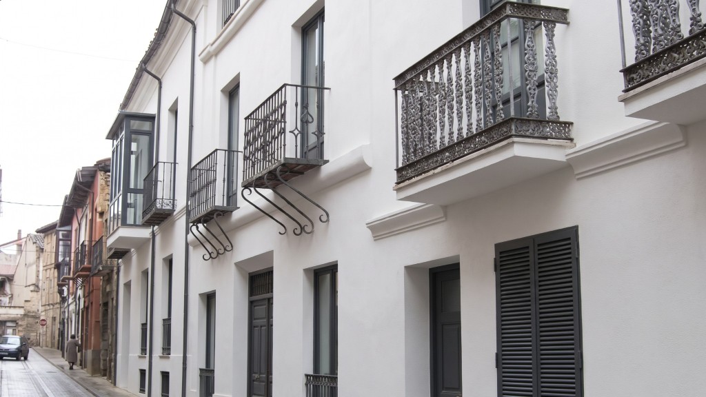The same facade renovated with white render and dark joinery, generated with Mix&Design