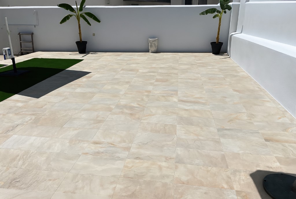 Outdoor terrace with beige tile, white walls and banana plants, starting photo for Mix&Design stamped concrete